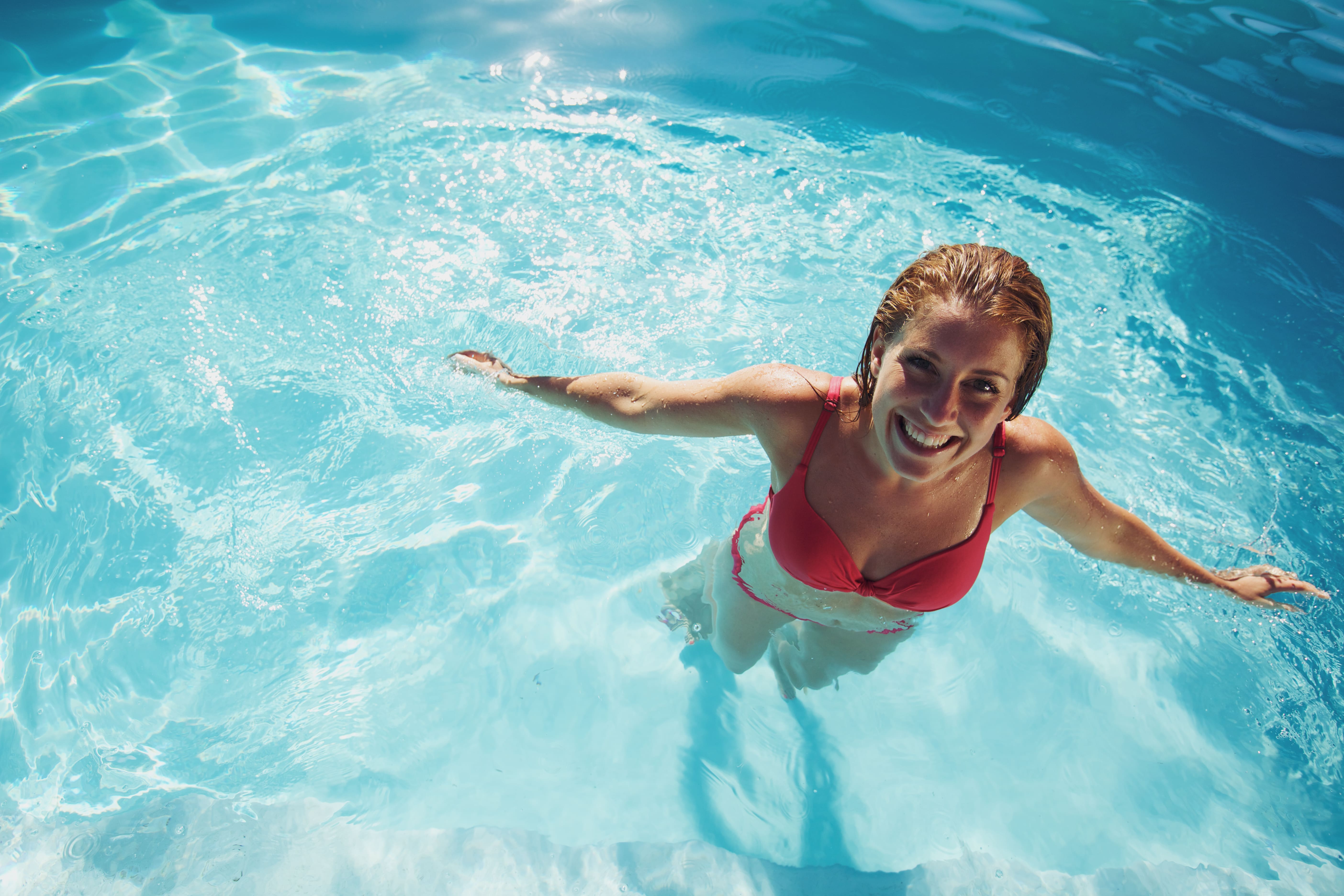 girl-standing-in-a-swimming-pool-smiling-2021-08-26-19-57-55-utc-min